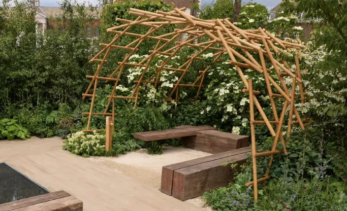 Flower garden with stone path through the centre, and "u" shaped wooden seating area below a wooden arch.